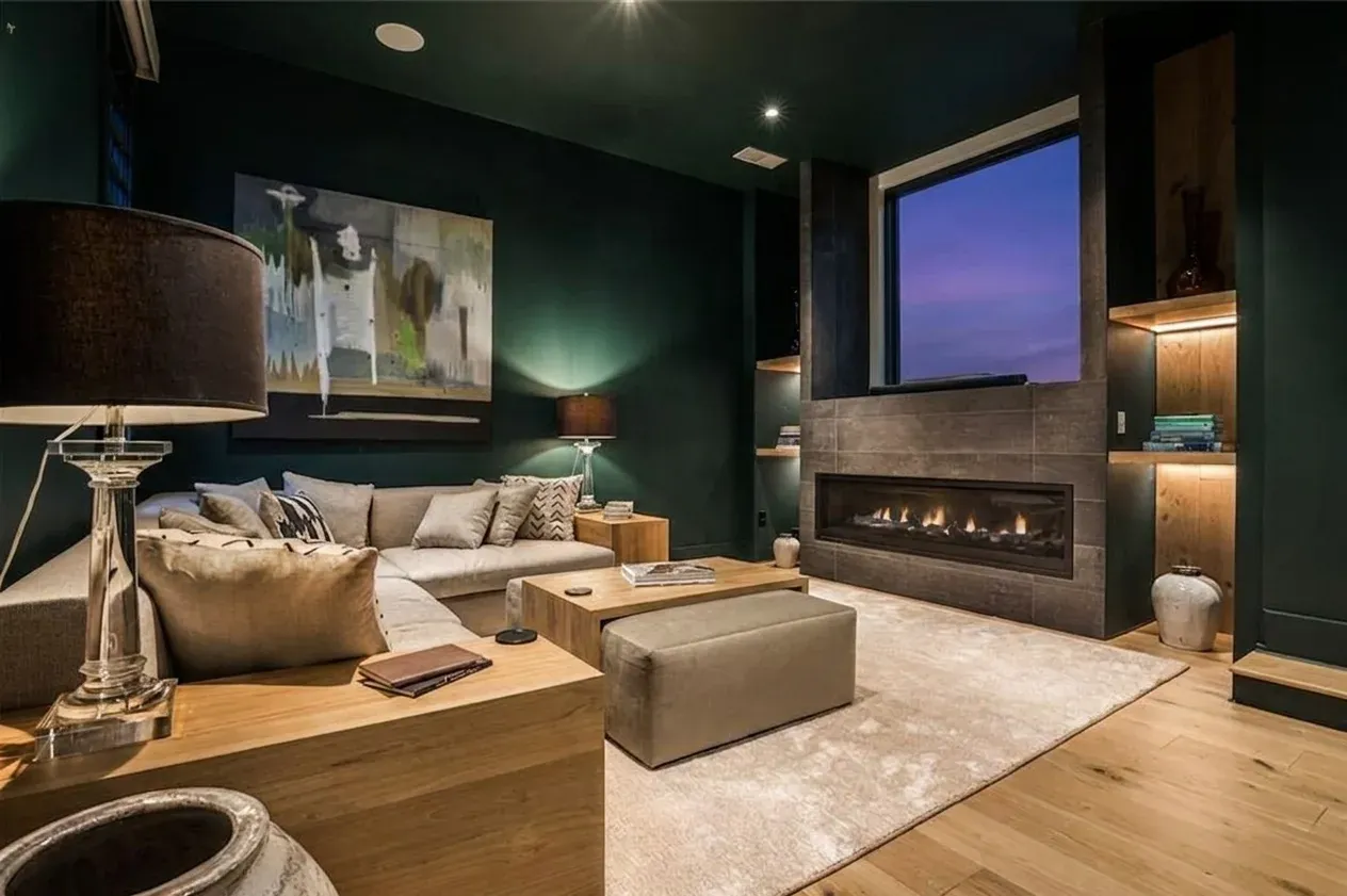 Daniel Allen Designs contemporary living room with teal walls, linear fireplace, and wood shelving in Buckhead, Georgia
