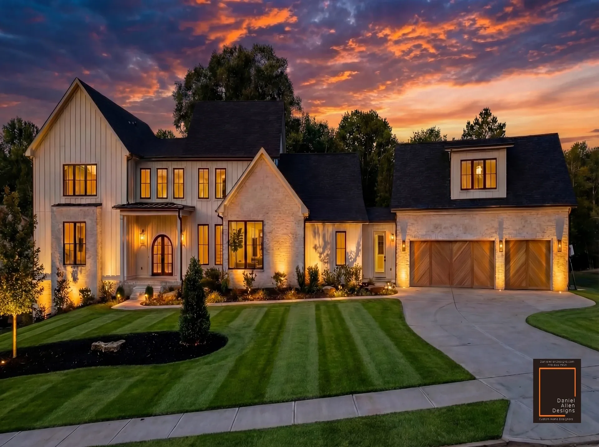 Daniel Allen Designs modern farmhouse custom home in Dunwoody, Georgia — white limestone and board-and-batten siding with arched entry and dusk lighting