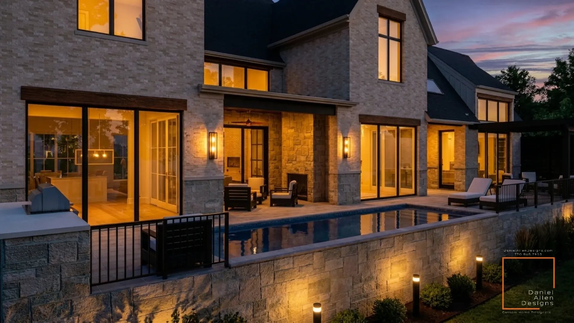 Daniel Allen Designs modern European stone manor pool and covered porch in Chastain Park, Georgia — stone fireplace patio looking into illuminated kitchen